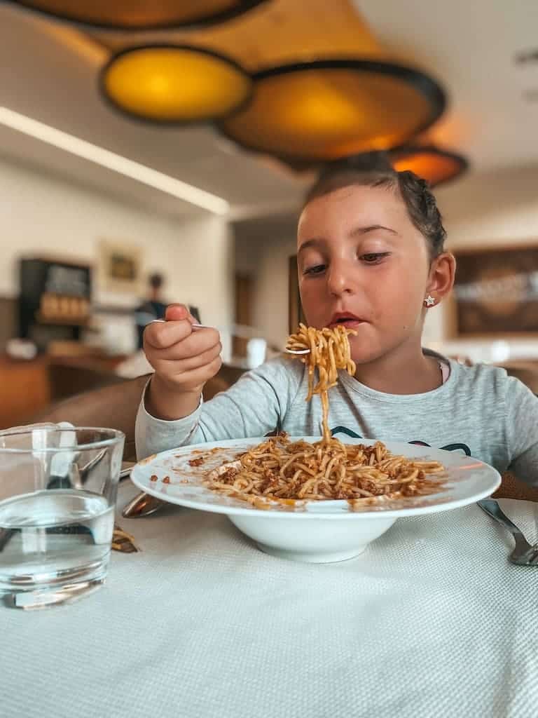 bambina mangia con gusto piatto di pasta